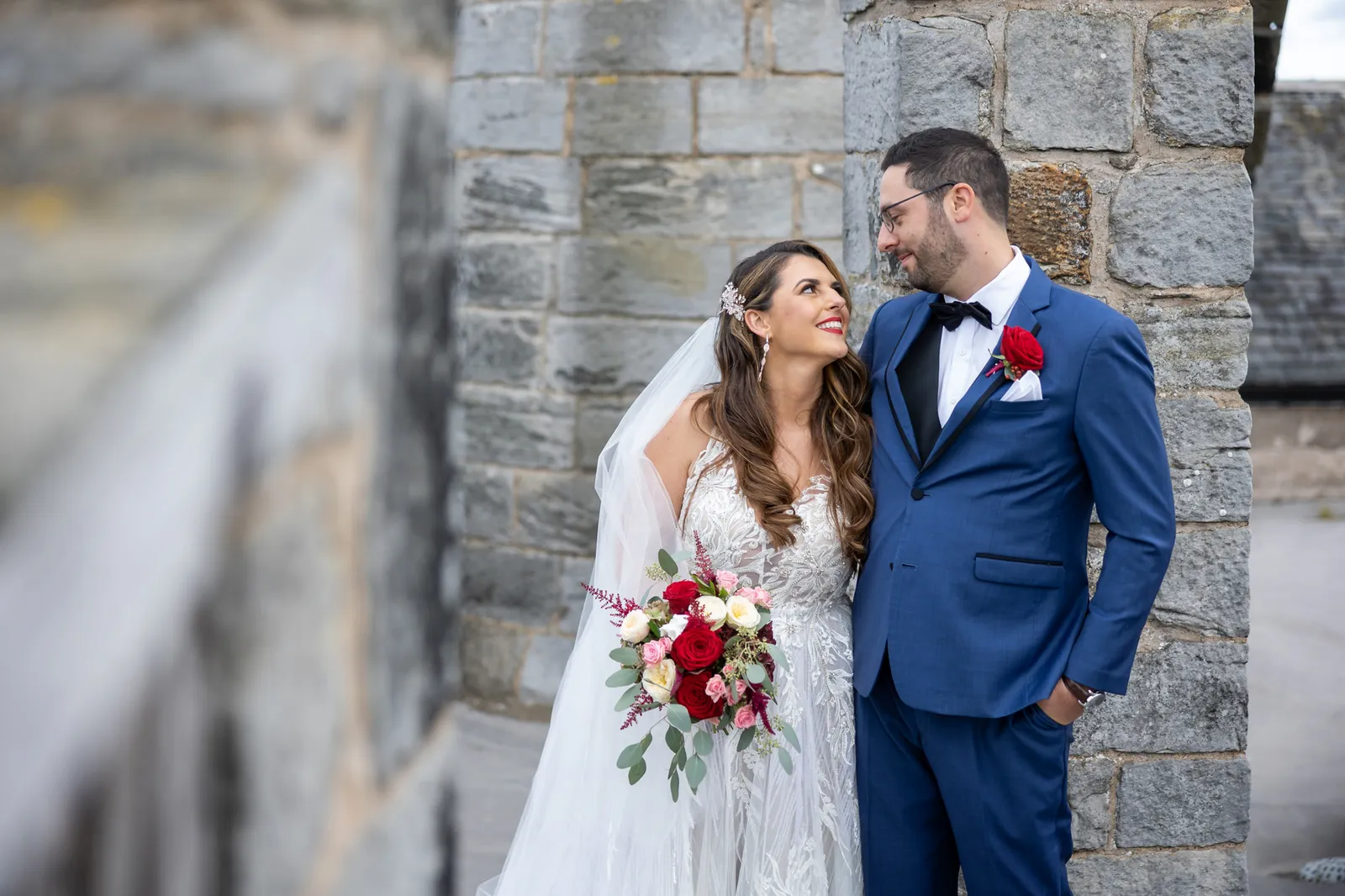 photo of bride and groom at city chambers wedding venue with red flowers
