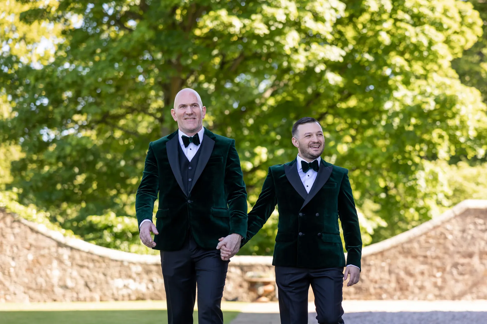 wedding couple in green velvet jackets walking at borthwick castle